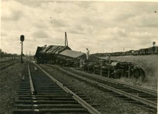 Sur une voie ferrée, ouvriers autour d'un train de munitions déraillé Sur une voie ferrée, ouvriers autour d'un train de munitions déraillé
