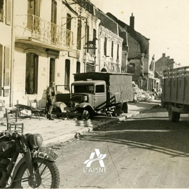 Les véhicules allemands circulent dans les rues de La Capelle encore marquées par les combats. © Arch. dép. Aisne 2 Fi 339